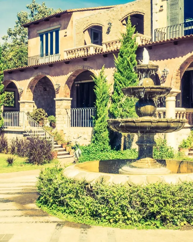 Mediterrane Villa mit Springbrunnen und geschnittenen Buchsbäumen